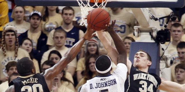 Wake Forest's Travis McKie (30) and Tyler Cavanaugh (34) combine to block a shot by Pittsburgh's Durand Johnson (5) in the second half of an NCAA college basketball game on Saturday, Jan. 11, 2014, in Pittsburgh. (AP Photo/Keith Srakocic)