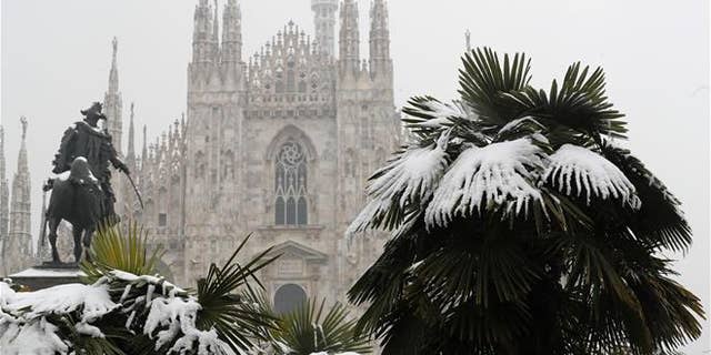 Palm trees are dusted in snow in front of Milan's Gothic Cathedral, Italy, on March 2, 2018.
