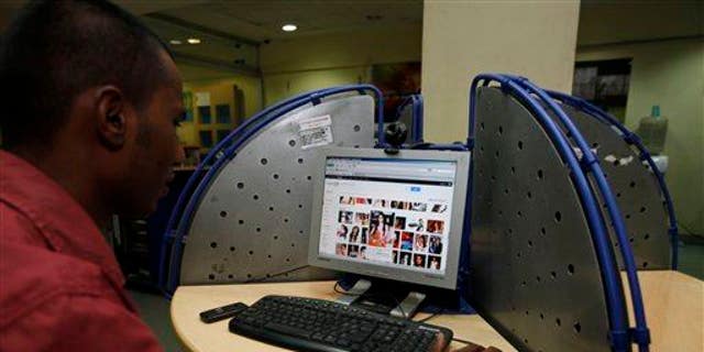 An Indian man surfs a Google page at an internet cafe in Hyderabad, India, Saturday, Jan. 14, 2012.