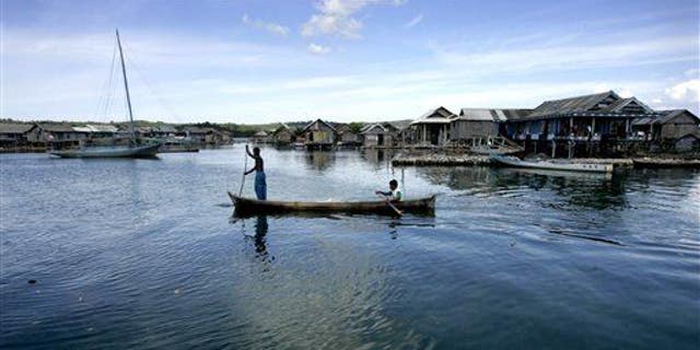 Men and women of the Bajau tribe row a boat at a fishing village on Kaledupa island, Southeast Sulawesi, Indonesia.