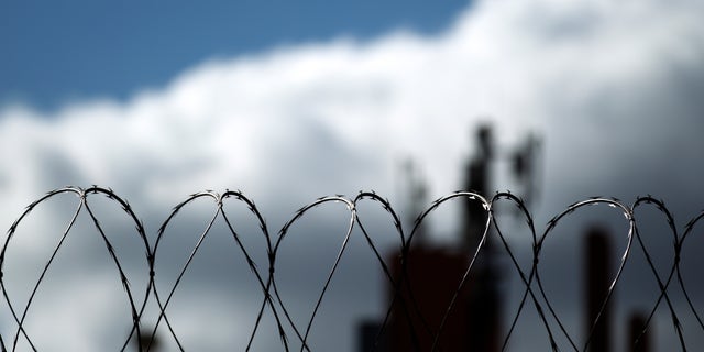 Razor wire sits atop a border fence as a building in the Mexican border city of Tijuana sits behind, as seen from San Diego. (AP Photo/Gregory Bull)