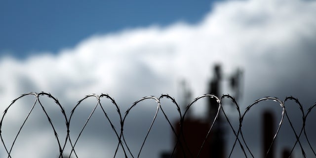 Razor wire sits atop a border fence as a building in the Mexican border city of Tijuana sits behind, as seen from San Diego. (AP Photo/Gregory Bull)