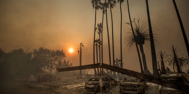 Smoke rises behind a leveled apartment complex as a wildfire burns in Ventura, California, Tuesday.
