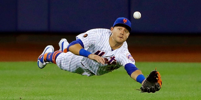 New York Mets center fielder Michael Conforto dives for but can't make a play on a ball hit by the Los Angeles Dodgers' Yasiel Puig during the eighth inning of a game June 23, 2018, in New York.