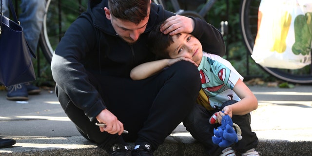 A man comforts a boy after a tower block was severly damaged by a serious fire, in north Kensington, West London, Britain June 14, 2017. REUTERS/Neil Hall - RTS1702W