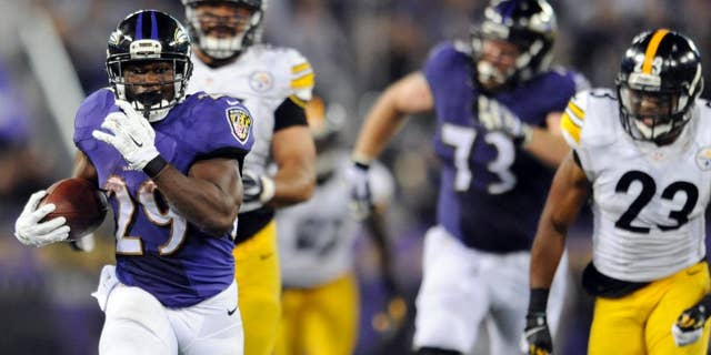 Baltimore Ravens running back Justin Forsett (29) runs away from Pittsburgh Steelers defensive end Cameron Heyward (97) and free safety Mike Mitchell (23) during the second half of an NFL football game Thursday, Sept. 11, 2014, in Baltimore. The Ravens won 26-6. (AP Photo/Gail Burton)