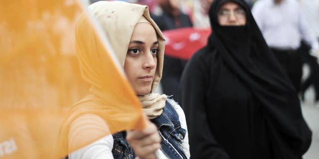 A supporter of Turkish Prime Minister Recep Tayyip Erdogan holds an AKP 'Justice and Development' party flag during a rally in Istanbul on June 16, 2013