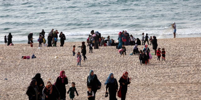 FILE - In this Thursday, Oct. 31, 2013 file photo, Palestinian families enjoy the beach of the Mediterranean Sea in Gaza City. Palestinians continue to have a higher rate of natural growth than Jews, and leading Israeli demographers have said the current slight Jewish majority in the Holy Land will disappear in a few years. Israelis in favor of a peace deal that cedes most of the war-won land to a Palestinian state usually point to the ``demographic time bomb'' as a prime motivator. (AP Photo/Adel Hana)