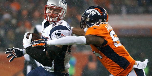 DENVER, CO - NOVEMBER 29: Patriots tight end Rob Gronkowski looks up field, picking up additional yardage after a catch before the Broncos' Brandon Marshall moved in for a tackle during first quarter action. The Denver Broncos hosted the New England Patriots for a regular season NFL game at Sports Authority Field at Mile High on Sunday, Nov. 29, 2015. (Photo by Matthew J. Lee/The Boston Globe via Getty Images)
