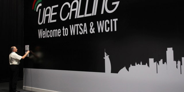 Dec. 3, 2012: An official sticks a note on the wall next to the conference banner during the eleventh day of the World Conference on International Telecommunication in Dubai, United Arab Emirates.