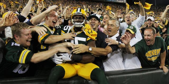 GREEN BAY, WI - SEPTEMBER 08: Greg Jennings #85 of the Green Bay Packers is mobbed by fans after leaping into the stands following a touchdown catch against the New Orleans Saints during the NFL opening season game at Lambeau Field on September 8, 2011 in Green Bay, Wisconsin. The Packers defeated the Saints 42-34. (Photo by Jonathan Daniel/Getty Images)