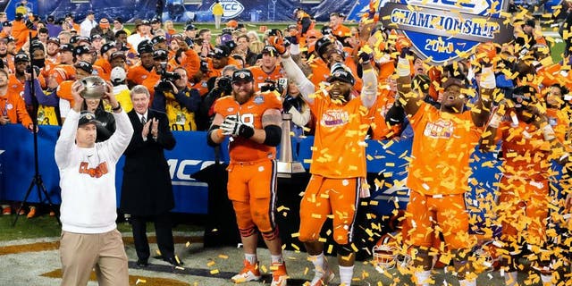 Dec 5, 2015; Charlotte, NC, USA; Clemson Tigers head coach Dabo Swinney (L) holds up the trophy for fans after winning the ACC football championship game at Bank of America Stadium. The Tigers won 45-37. Mandatory Credit: Jim Dedmon-USA TODAY Sports