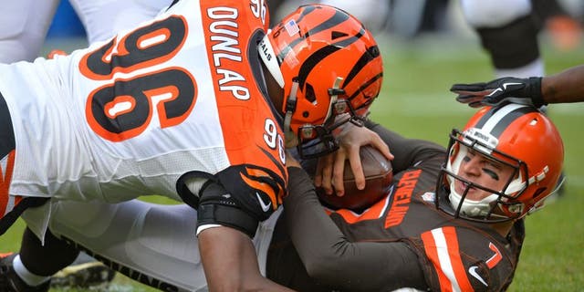 Cleveland Browns quarterback Austin Davis (7) is tackled by Cincinnati Bengals defensive end Carlos Dunlap (96) in the first half of an NFL football game, Sunday, Dec. 6, 2015, in Cleveland. (AP Photo/David Richard)