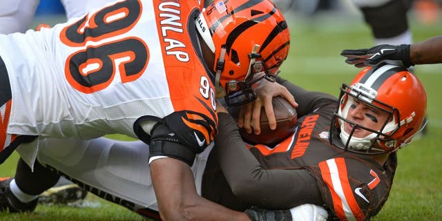 Cleveland Browns quarterback Austin Davis (7) is tackled by Cincinnati Bengals defensive end Carlos Dunlap (96) in the first half of an NFL football game, Sunday, Dec. 6, 2015, in Cleveland. (AP Photo/David Richard)