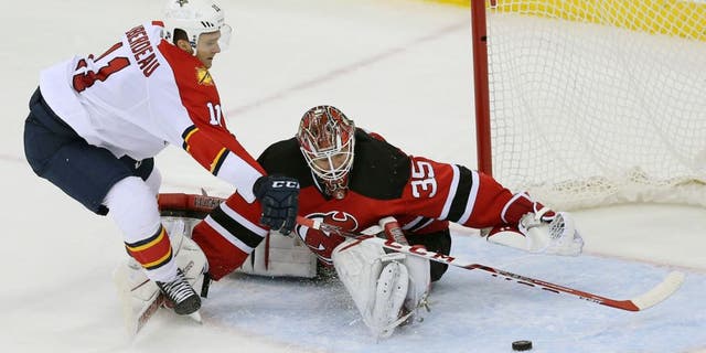 Florida Panthers left wing Jonathan Huberdeau (11) is unable to score on a penalty shot as New Jersey Devils goalie Cory Schneider (35) makes a save during the second period of an NHL hockey game Sunday, Dec. 6, 2015, in Newark, N.J. (AP Photo/Mel Evans)