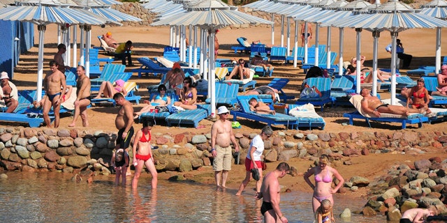 Dec. 6: Tourists sunbathe and stand in the shallow waters at the Egyptian Red Sea resort of Sharm el-Sheikh, Egypt.