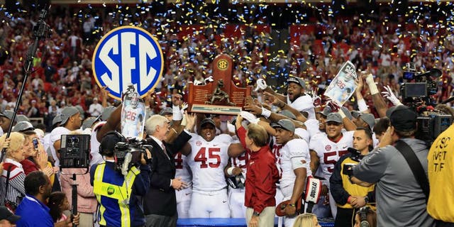 Dec 6, 2014; Atlanta, GA, USA; Alabama Crimson Tide head coach Nick Saban and his team celebrate with the trophy after the 2014 SEC Championship Game against the Missouri Tigers at the Georgia Dome. Alabama defeated Missouri 42-13. Mandatory Credit: Kevin Liles-USA TODAY Sports