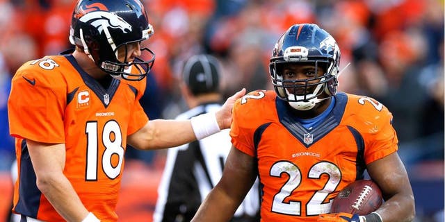 Denver Broncos running back C.J. Anderson, right, celebrates his touchdown with quarterback Peyton Manning during the second half in an NFL football game Sunday, Dec. 7, 2014, in Denver. (AP Photo/David Zalubowski)
