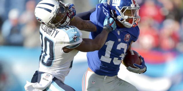 Dec 7, 2014; Nashville, TN, USA; New York Giants wide receiver Odell Beckham Jr (13) carries the ball against Tennessee Titans cornerback Jason McCourty (30) during the second half at LP Field. The Giants beat the Titans 36-7. Mandatory Credit: Don McPeak-USA TODAY Sports