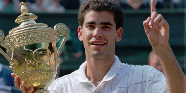 Pete Sampras indicates he is number one while holding his trophy after defeating Boris Becker to win the Men's Single's Final on Centre Court at Wimbledon, in this July 9, 1995 file photo.
