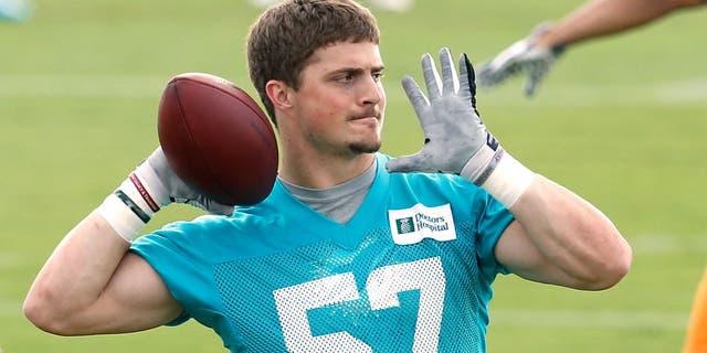 DAVIE, FL - MAY 27: Jordon Tripp #57 of the Miami Dolphins throws the ball during the teams first OTA on May 27, 2014 at the Miami Dolphins training facility in Davie, Florida. (Photo by Joel Auerbach/Getty Images)