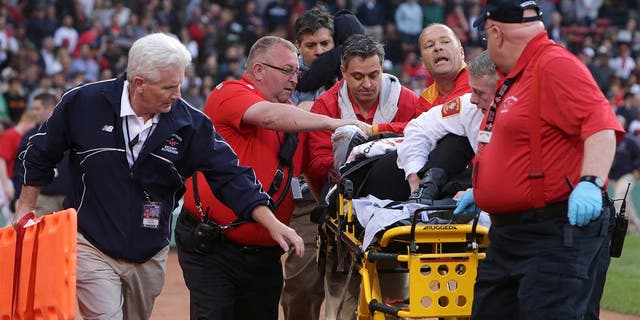 BOSTON - JUNE 5: Medical personnel remove a fan injured by a broken bat in the second inning. The Boston Red Sox take on the Oakland Athletics in Game 1 of a three game series at Fenway Park. (Photo by Barry Chin/The Boston Globe via Getty Images)