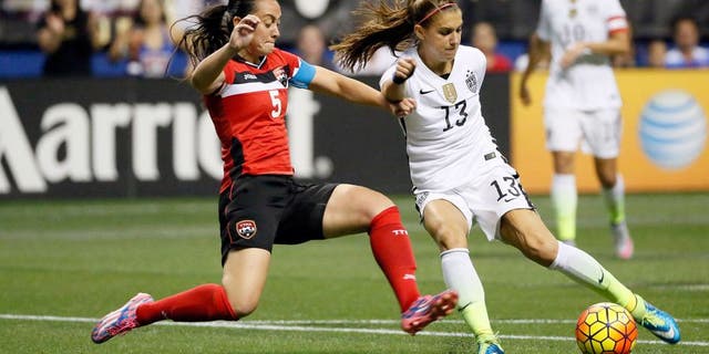Dec 10, 2015; San Antonio, TX, USA; United States forward Alex Morgan (13) is defended by Trinidad & Tobago defender Arin King (5) during the first half at Alamodome. Mandatory Credit: Soobum Im-USA TODAY Sports