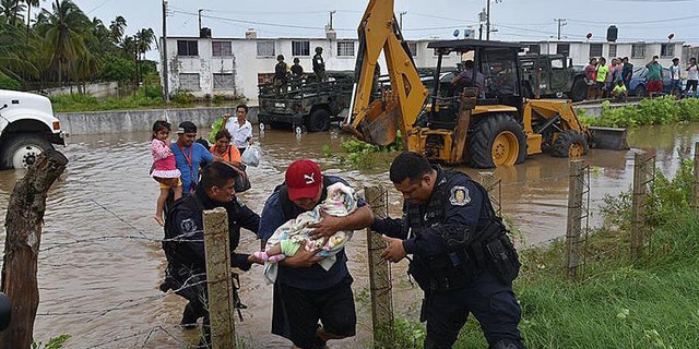 A handout photo released by Mexican news agency Quadratin shows people being evacuated by members Guerrero State Police after floods due heavy rains in the state of Guerrero, Mexico, 04 September 2016. EFE
