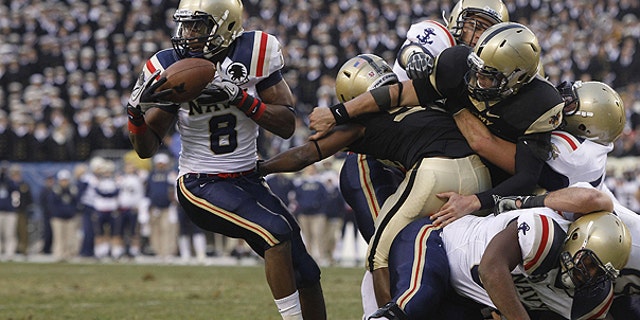 Dec. 11: Navy safety Wyatt Middleton, left, grabs a loose ball from Army quarterback Trent Steelman, right, in the first half of an NCAA college football game, in Philadelphia.