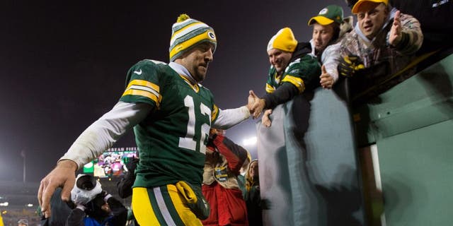 Dec 8, 2014; Green Bay, WI, USA; Green Bay Packers quarterback Aaron Rodgers (12) high fives fans following the game against the Atlanta Falcons at Lambeau Field. Green Bay won 43-37. Mandatory Credit: Jeff Hanisch-USA TODAY Sports