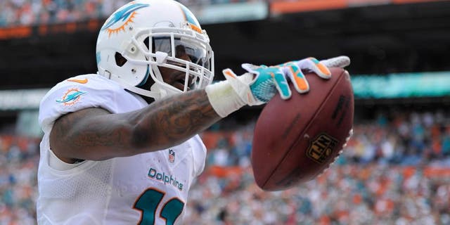 Dec 15, 2013; Miami Gardens, FL, USA; Miami Dolphins wide receiver Mike Wallace (11) celebrates his touchdown against the New England Patriots in the first half of the game at Sun Life Stadium. Mandatory Credit: Brad Barr-USA TODAY Sports