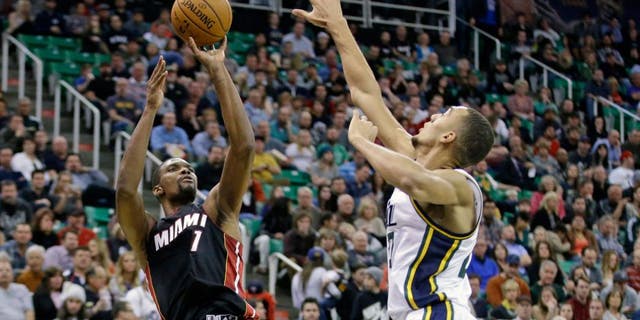 Miami Heat center Chris Bosh (1) shoots as Utah Jazz center Rudy Gobert, right, defends in the second quarter during an NBA basketball game Friday, Dec. 12, 2014, in Salt Lake City. (AP Photo/Rick Bowmer)