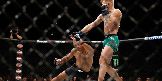LAS VEGAS, NV - DECEMBER 12: (R-L) Conor McGregor of Ireland punches Jose Aldo of Brazil in their UFC featherweight championship bout during the UFC 194 event inside MGM Grand Garden Arena on December 12, 2015 in Las Vegas, Nevada. (Photo by Christian Petersen/Zuffa LLC/Zuffa LLC via Getty Images)
