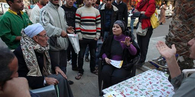 December 9, 2011: Egyptian Parliamentary candidate Abeer Hamdy, center right, sits with local residents as she campaigns in 6th of October, a suburb of Cairo.