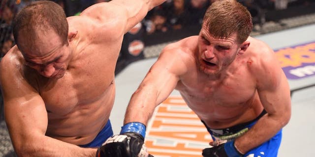 PHOENIX, AZ - DECEMBER 13: (R-L) Stipe Miocic punches Junior Dos Santos of Brazil in their heavyweight fight during the UFC Fight Night event at the U.S. Airways Center on December 13, 2014 in Phoenix, Arizona. (Photo by Josh Hedges/Zuffa LLC/Zuffa LLC via Getty Images)