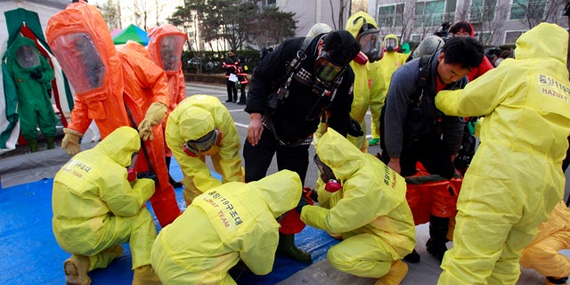 Dec. 15: South Korean hazmat team members wearing anti-chemical suits prepare a civil defense drill from a possible North Korea chemical attack near the border city between the two Koreas in Paju, South Korea.