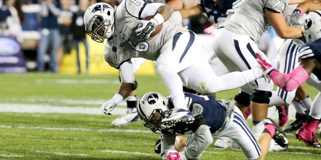 Oct 18, 2014; Provo, UT, USA; Nevada Wolf Pack running back Don Jackson (6) is tackled by Brigham Young Cougars defensive back Kai Nacua (12) during the second quarter at Lavell Edwards Stadium. Mandatory Credit: Chris Nicoll-USA TODAY Sports