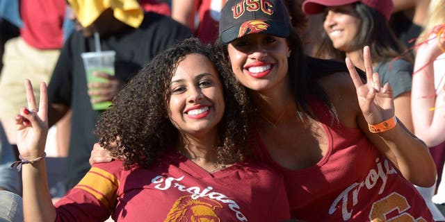 Nov 29, 2014; Los Angeles, CA, USA; Southern California Trojans fans Sarina Strickland (left) and Natasha Strickland react against the Notre Dame Fighting Irish at Los Angeles Memorial Coliseum. USC defeated Notre Dame 49-14. Mandatory Credit: Kirby Lee-USA TODAY Sports