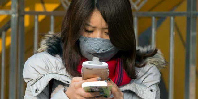 Dec. 19, 2015: A woman wears a mask during a polluted day in Beijing, China.