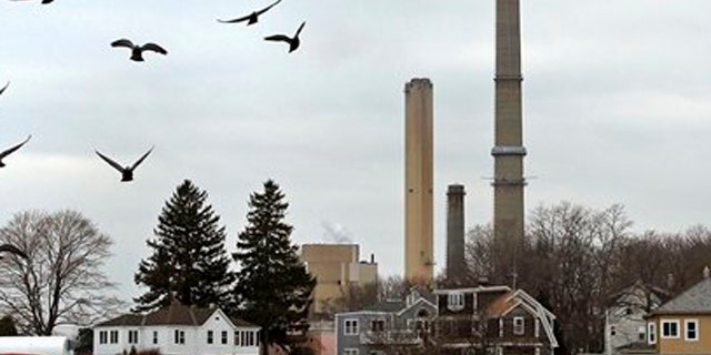 December 14, 2011: Pigeons fly past as the stacks of Dominion's power plant tower over a nearby neighborhood in Salem, Mass.
