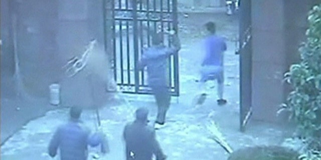 People chase a man (R), who attacked students with a knife, out of an elementary school in Guangshan county, Henan province, in this still image from a December 14, 2012 surveillance video, released by local police December 18, 2012.