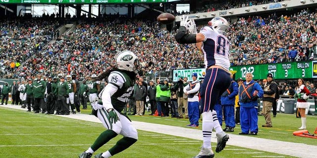 EAST RUTHERFORD, NJ - DECEMBER 21: Tight end Rob Gronkowski #87 of the New England Patriots catches a touchdown in the second quarter as free safety Calvin Pryor #25 of the New York Jets defends during a game at MetLife Stadium on December 21, 2014 in East Rutherford, New Jersey. (Photo by Alex Goodlett/Getty Images)