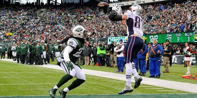 EAST RUTHERFORD, NJ - DECEMBER 21: Tight end Rob Gronkowski #87 of the New England Patriots catches a touchdown in the second quarter as free safety Calvin Pryor #25 of the New York Jets defends during a game at MetLife Stadium on December 21, 2014 in East Rutherford, New Jersey. (Photo by Alex Goodlett/Getty Images)