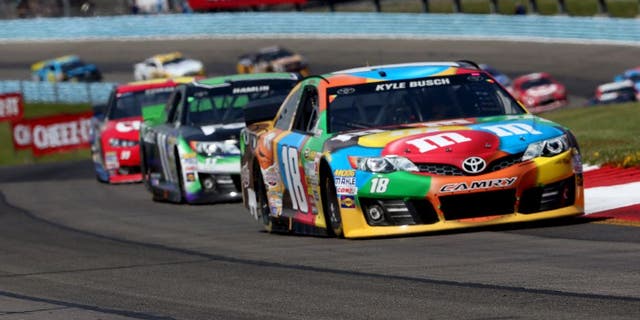 WATKINS GLEN, NY - AUGUST 10: Kyle Busch, driver of the #18 M&M's Toyota, leads a pack of cars during the NASCAR Sprint Cup Series Cheez-It 355 at Watkins Glen International on August 10, 2014 in Watkins Glen, New York. (Photo by Mark Wilson/Getty Images)