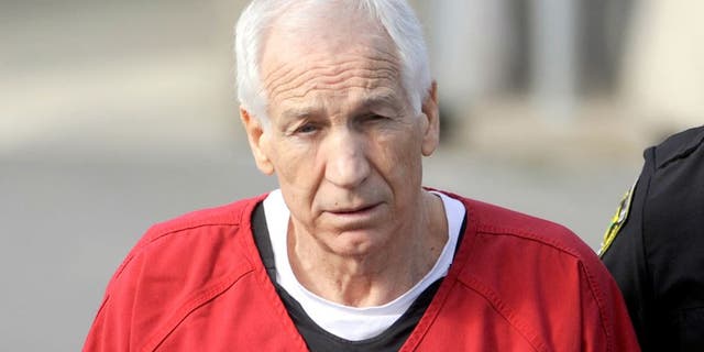 Jerry Sandusky, center, is escorted from his sentencing at the Centre County Courthouse in Bellefonte on Tuesday, October 9, 2012. Sandusky, maintaining his innocence, was sentenced Tuesday to at least 30 years in prison, effectively a life sentence, in the child sexual abuse scandal that brought shame to Penn State and led to coach Joe Paterno's downfall. (Christopher Weddle/Centre Daily Times/MCT)