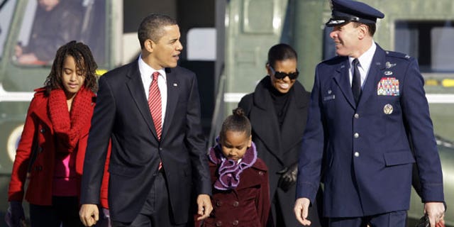 Thursday: President Barack Obama, walks with Malia Obama, 11, left, Sasha Obama 8, and Michelle Obama, with Col. Steven Shepro, to Air Force One at Andrews Air Force Base, Md., on their way to Hawaii for Christmas. (AP Photo)