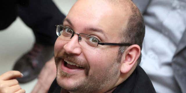 In this April 11, 2013 photo, Jason Rezaian, an Iranian-American correspondent for the Washington Post, smiles as he attends a presidential campaign of President Hassan Rouhani in Tehran, Iran.