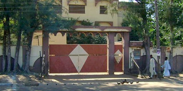 Sunday: Unidentified men walk in front of the house of Umaru Abdul Mutallab, the father of Umar Farouk Abdulmutallab, the alleged Christmas Day terrorist, in Funtua, Katsina state, Nigeria. The house serves as family residence but is only attended to when there is a wedding ceremony because the extended family lives either in Kaduna, Abuja, or overseas. (AP Photo)