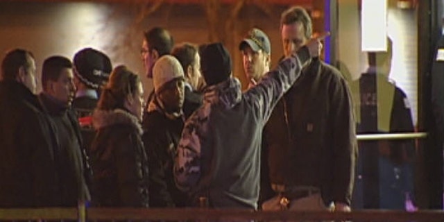 December 27, 2011: Onlookers stand outside the scene of a shooting in Chicago.