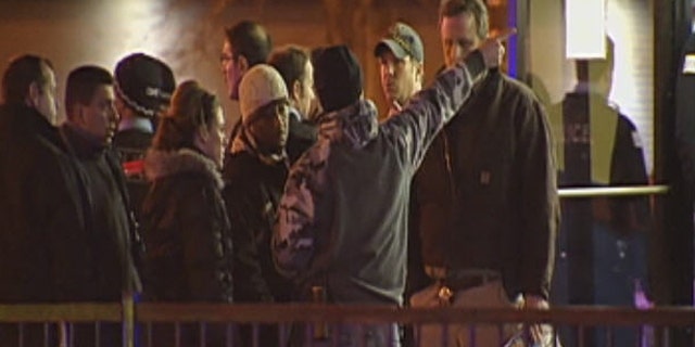 December 27, 2011: Onlookers stand outside the scene of a shooting in Chicago.